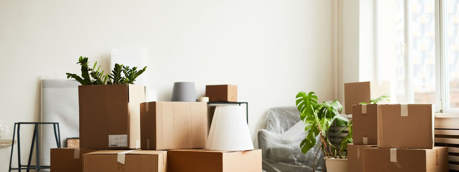 Gestapelte Umzugskartons in einer hellen, noch leeren Wohnung