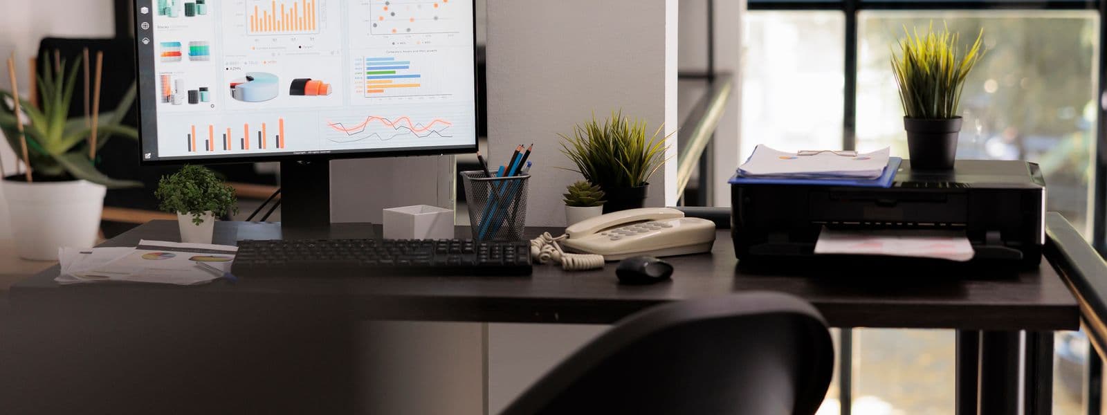 Arbeitsplatz einer Verwaltung mit Bildschirm voller Auswertungen