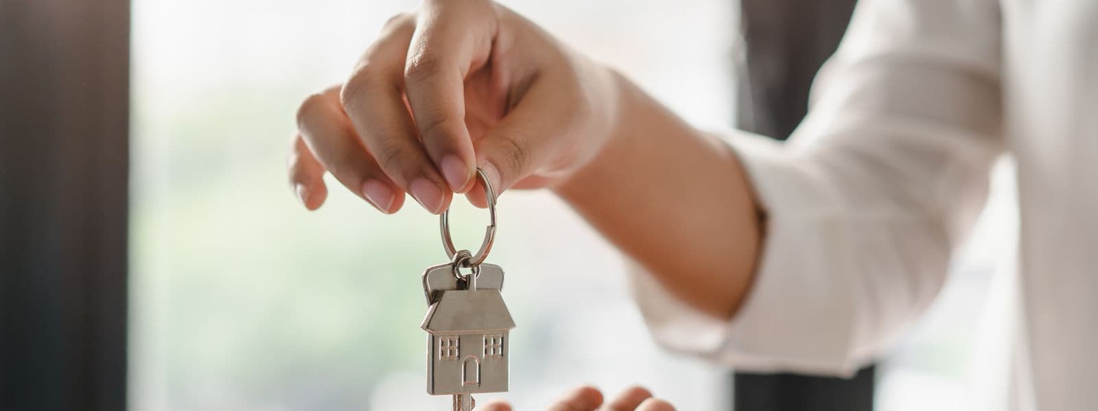 Wohnungsschlüssel werden von einer Hand in die andere gegeben