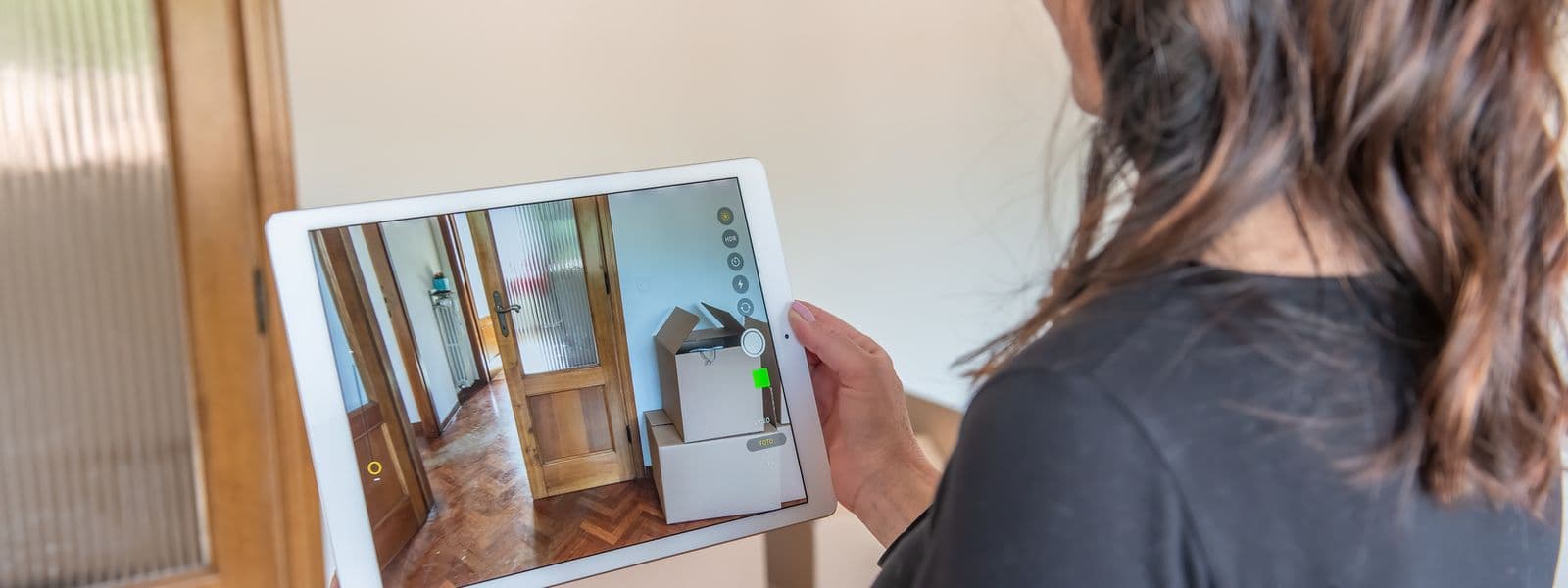 Frau nimmt einen Wohnraum mit einem Tablet auf